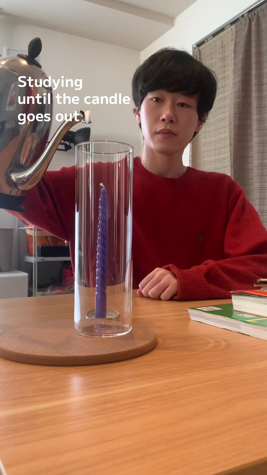 A time-lapse of a student studying at a desk with a single lit candle next to notebooks